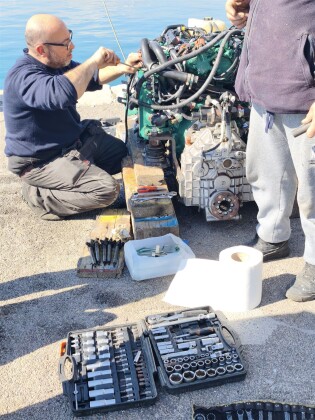 Mechanics overhauling a marine engine on the quay – SailorOne