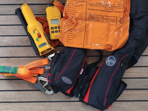 Life jackets, first-aid kit, handheld VHF and safety lines on a teak deck – SailorOne
